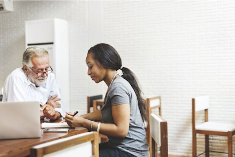 A school counselor and student work at a desk.