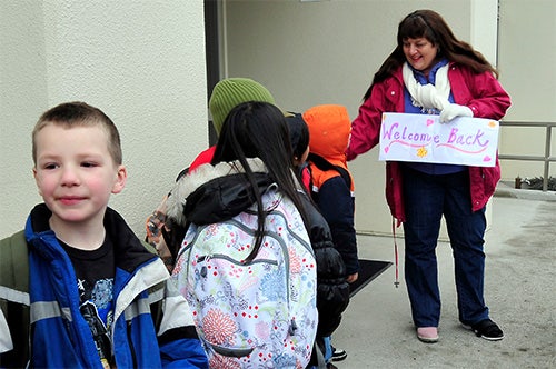 A school counselor welcomes students back for the school year.